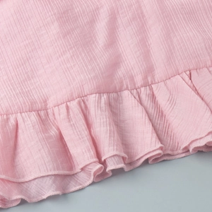 Close-up detail of pink ruffled hem with vertical texture on summer camisole top