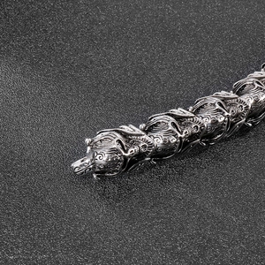 Détail macro du bracelet punk montrant les maillons en écailles de dragon et fini argenté