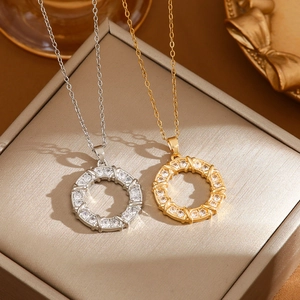 Elegant gold and silver donut pendant necklaces with sparkling zircon pave on a gift box