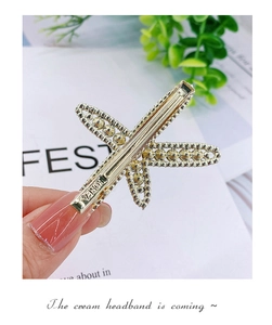 Close-up of golden starfish hair clip with crystal beads and engraved Korea logo