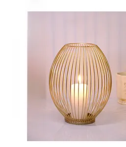 Macro detail of Nordic gold wire birdcage candle holder with warm lit pillar candle inside