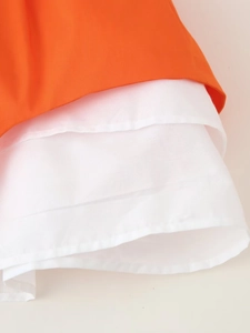 Détail de l'ourlet de robe orange avec doublure en tissu blanc à plusieurs couches