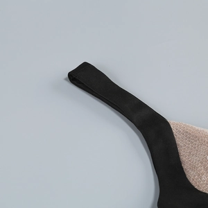 Détail de couture des bretelles noires et maille à paillettes dorées de la robe