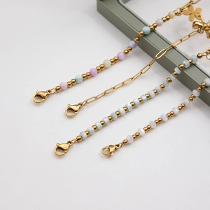 Détail de divers bracelets en acier inoxydable doré 18K avec perles colorées et fleurs