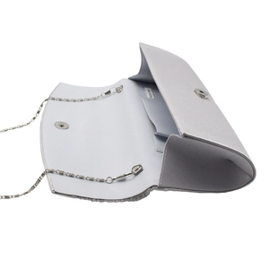 Detailed interior of silver satin evening clutch with metal chain and small pocket