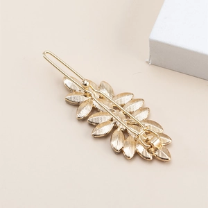 Minimalist gold leaf hair clip for women with elegant rhinestone accents on metal
