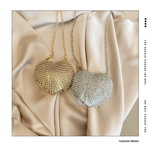 Detail of heart-shaped mini evening bags encrusted with shiny rhinestones in gold and silver