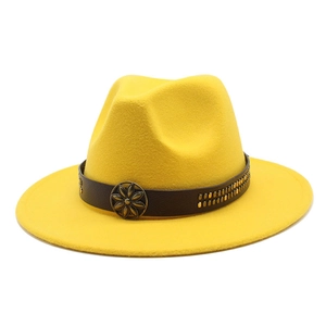 Detail of yellow wool fedora hat featuring brown leather band and bronze floral emblem