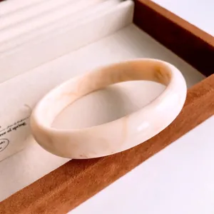 Bracelet jonc minimaliste en résine à motif marbré crème sur support de bijoux