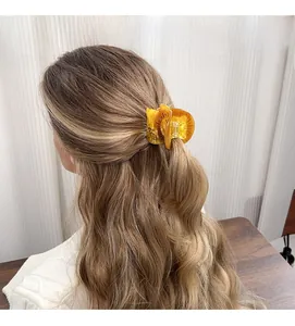 Detail of amber acetate forest animal hair claw clip styled on woman's half-up hair