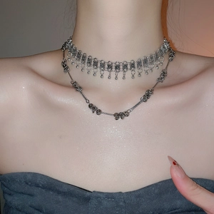Detail of vintage silver fringe necklace with beaded tassel and layered metallic chain