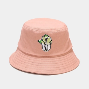 Close-up of a pink cotton bucket hat featuring detailed green bok choy embroidery