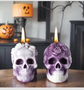 Detail of rose embossed skull candles in purple and white gradient for Halloween decor