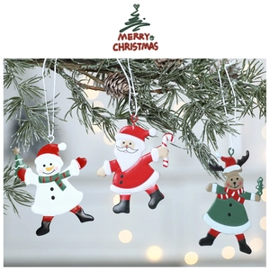 Close-up of metal snowman and Santa ornaments hanging on festive pine branches with bokeh