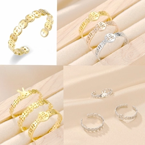 Close-up of gold titanium rings with ancient coin patterns and rabbit charm details