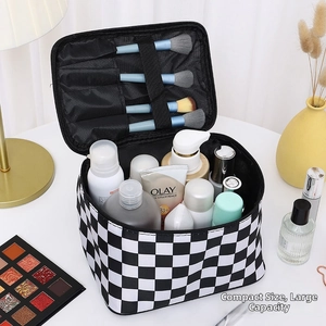 Interior detail of checkerboard makeup bag showing brush slots and large capacity storage