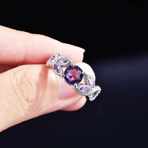 Detail of round purple amethyst ring with marquise side stones and vine-style silver band