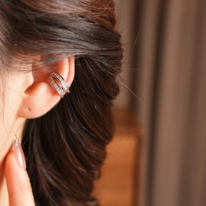 Close-up of silver double-layered ear cuff with zircon stones on female ear