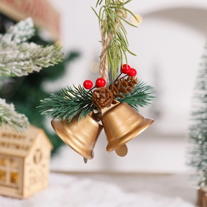 Detail of Christmas gold bells with pine cones, needles, and red berries on jute rope