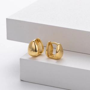 Polished gold teardrop huggie earrings made of S925 sterling silver in minimalist style