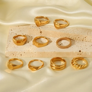 Macro view of golden stainless steel rings set on beige stone and cream silk