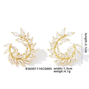 Macro shot of gold wheat leaf earrings with marquise cut cubic zirconia stones