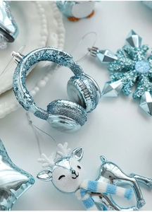 Close-up of ice blue glitter Christmas ornaments featuring headphones, deer, and snowflakes