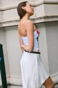Detail view of white tube top featuring red rose print and matching shorts with black belt