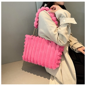 Detail of pink faux fur tote bag with striped texture and bubble handles with gold chains