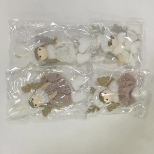 Detail of plush Christmas angel dolls with glitter antlers and wings in clear packaging