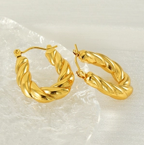 Detailed macro view showing the twisted croissant texture of gold plated hoop earrings