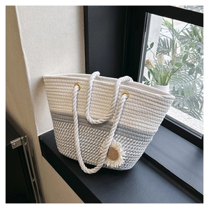Detail of hand-woven cotton tote bag featuring white daisy decor and thick rope handles
