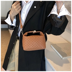 Detailed view of brown woven texture handbag with top handle and adjustable shoulder strap
