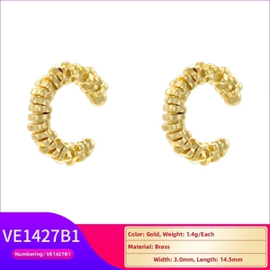 Detailed macro view of gold brass C-shaped ear cuffs with grooved texture and 14.5mm size