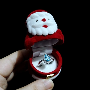 Teardrop blue gemstone ring with white diamonds inside Santa Claus velvet jewelry box