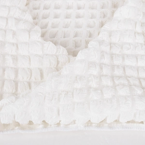 Close-up macro of white waffle weave fabric texture with soft 3D square pattern detail