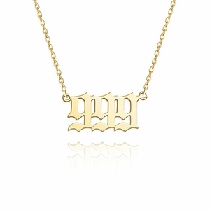 Detail of 14K gold stainless steel 1989 number pendant necklace with a clear reflection