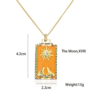 Detail view of 18K gold plated tarot moon pendant with orange enamel and colorful crystals