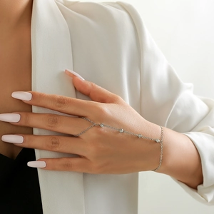 Close-up of a silver hand chain bracelet featuring delicate rhinestones and pearls