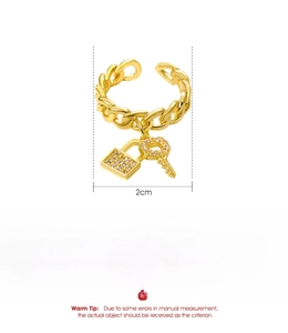 Detailed view of gold chain ring with padlock and key charms showing 2cm size specs