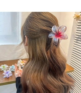 Detail of elegant plumeria flower hair claw clip with colorful gradient resin petals
