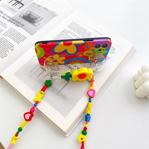 Floral iPhone case with colorful beaded crossbody strap on an aesthetic magazine background
