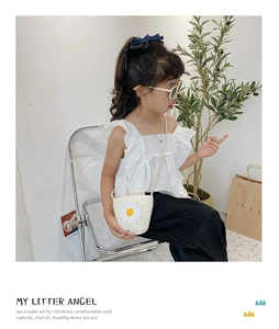 Dettaglio della borsa in paglia per bambini con fiore di margherita e trama intrecciata