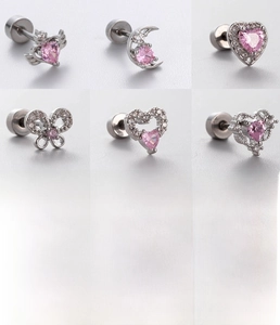 Macro shot of silver titanium steel cartilage studs with pink zircon hearts and butterflies