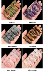 Macro shot of assorted natural crystal arrowheads including Amethyst and Tiger Eye stones