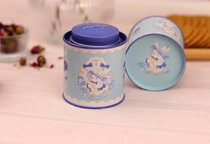 Close-up of a blue tin canister featuring a cute bunny illustration and floral decor
