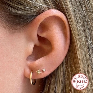 Close-up of 925 sterling silver earring set with star and cz studs on a model ear