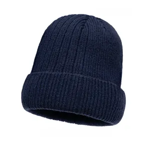 Detail of navy blue ribbed knit beanie with fold-over cuff and small leather brand patch