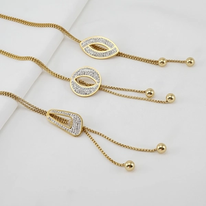 Long gold-tone sweater necklace with sparkling tassel pendants in three geometric shapes