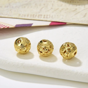 Macro shot of gold hollow round beads with butterfly patterns for DIY jewelry making